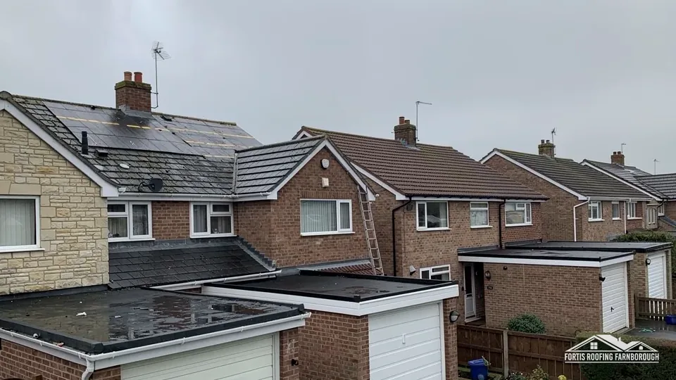 Flat-roofed garages and extensions behind a row of brick semi-detached houses